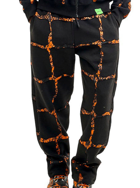 Person wearing a black and orange tie-dye hoodie and pants set on a white background