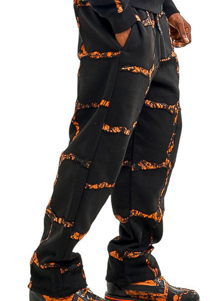 Person wearing a black and orange patterned outfit on a white background
