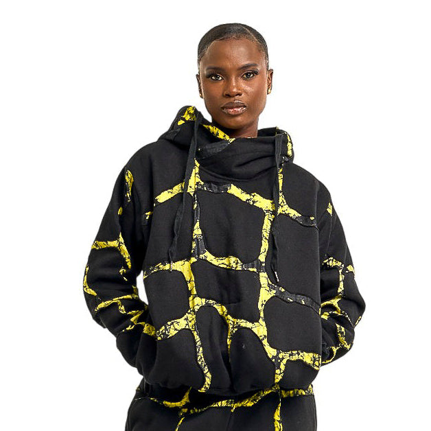 Person wearing a black and yellow patterned outfit with matching boots on a white background