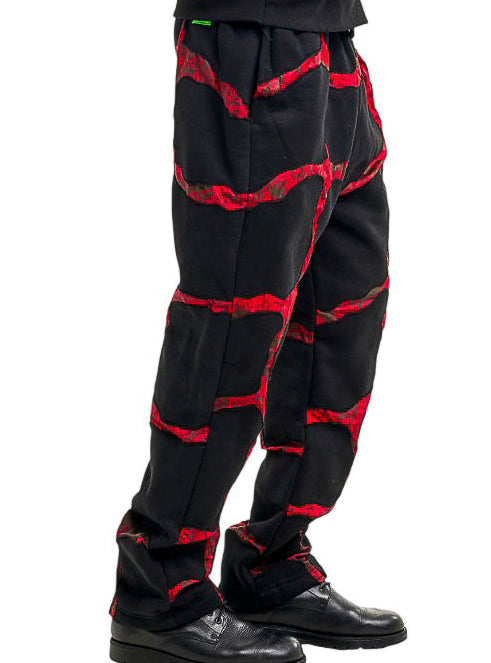 Person wearing a black and red patterned pants on a white background