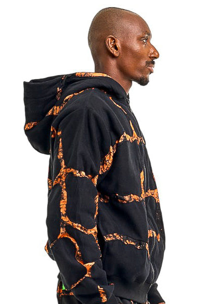 Person wearing a black and orange patterned outfit on a white background